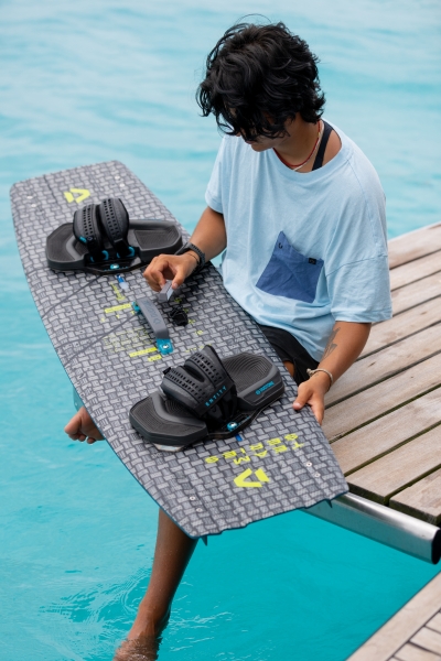 Produktbild Duotone Kitebindung Entity Ergo 2025 Ansicht Model hält Kiteboard mit Kitebindung